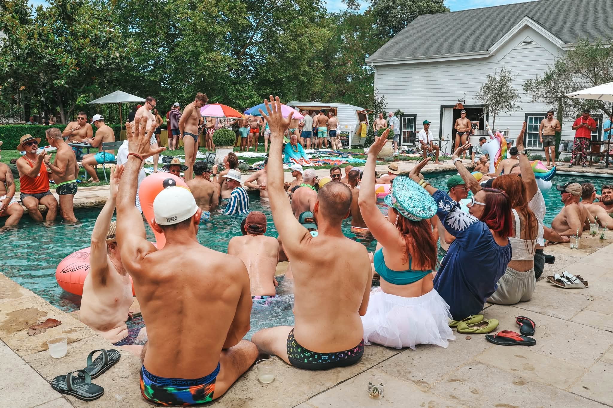 Pool party crowd with hands raised